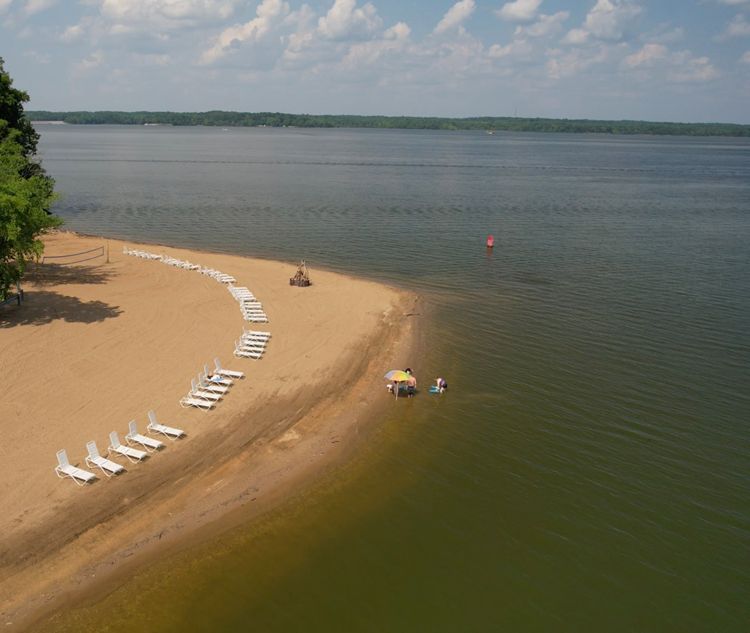 An aerial view of a beach with chairs and umbrellas