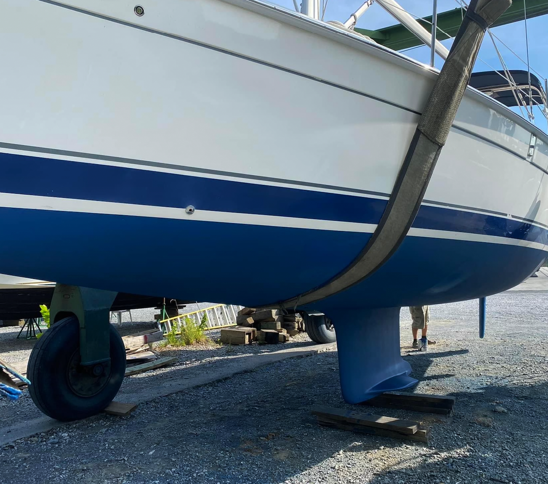 A blue and white boat is sitting on the ground