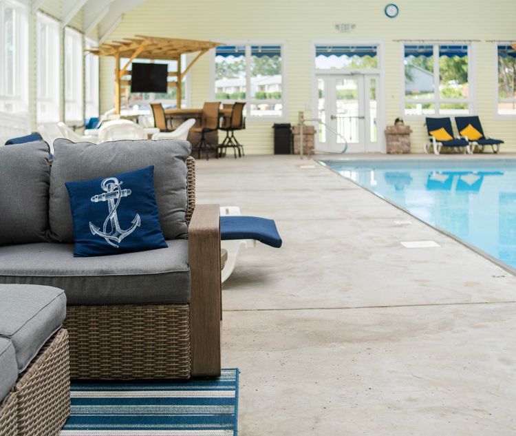 A living room with a couch and a pool in the background