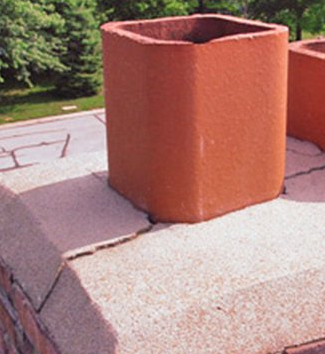 Two brick chimneys are sitting on top of a brick roof.