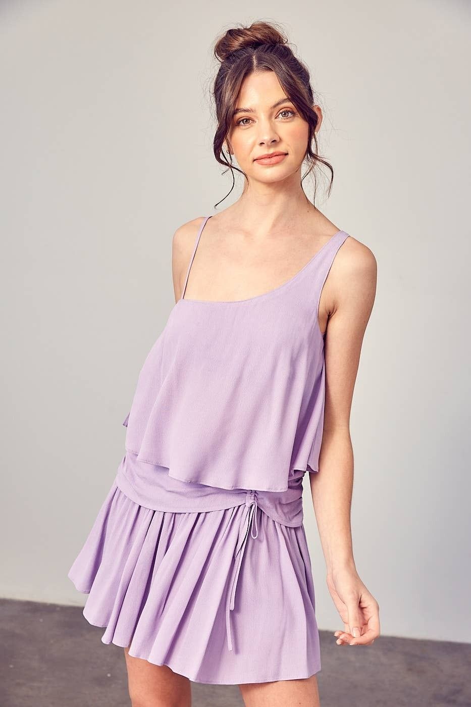 A woman is wearing a purple dress and a purple tank top.