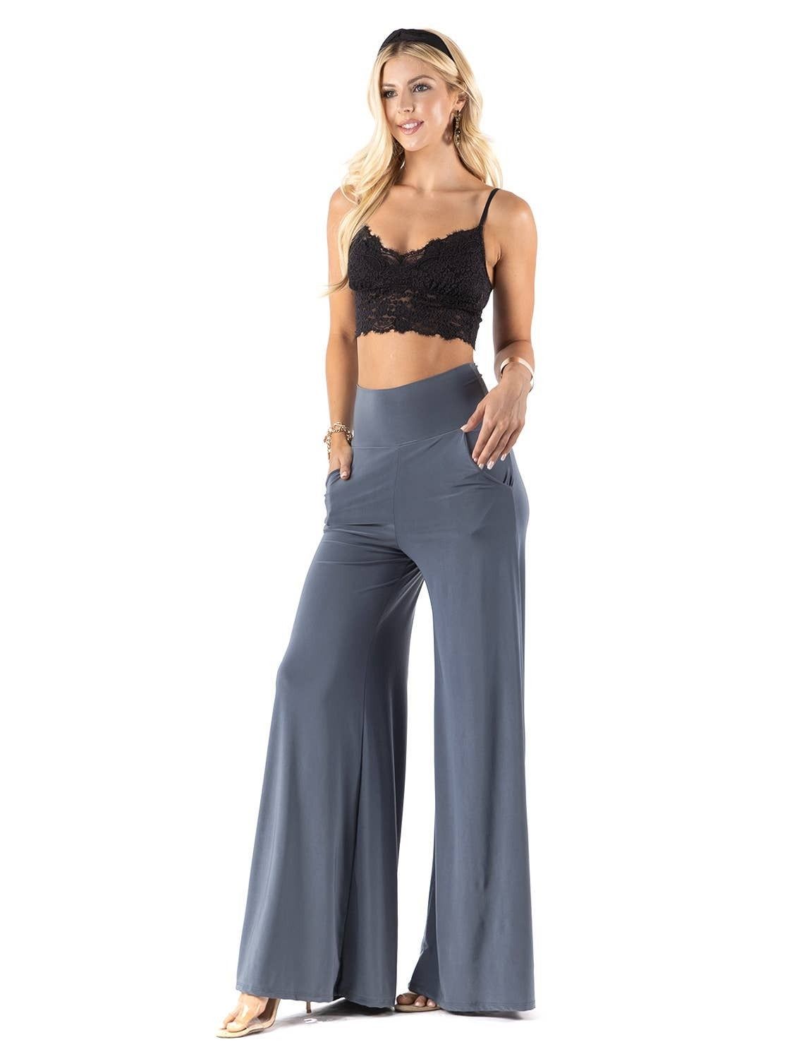 A woman is wearing a black crop top and wide leg pants.