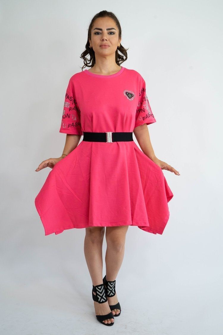 A woman is wearing a pink dress and black shoes.