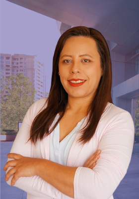 Una mujer con una camisa blanca está de pie con los brazos cruzados.