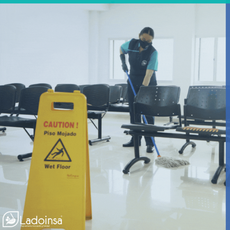 Un hombre está fregando el suelo junto a un cartel amarillo que dice 