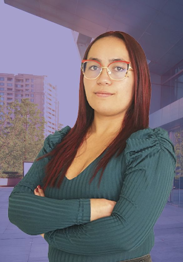 Una mujer que lleva gafas y un suéter verde está parada con los brazos cruzados.