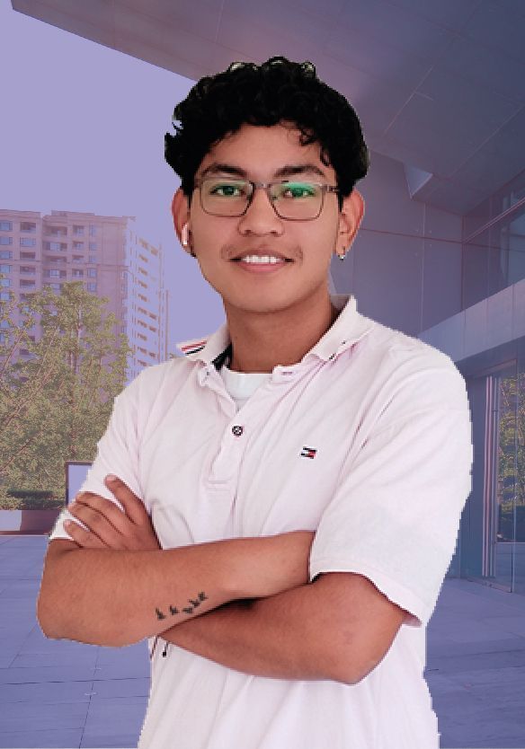 Un joven que lleva gafas y una camisa blanca está de pie con los brazos cruzados.