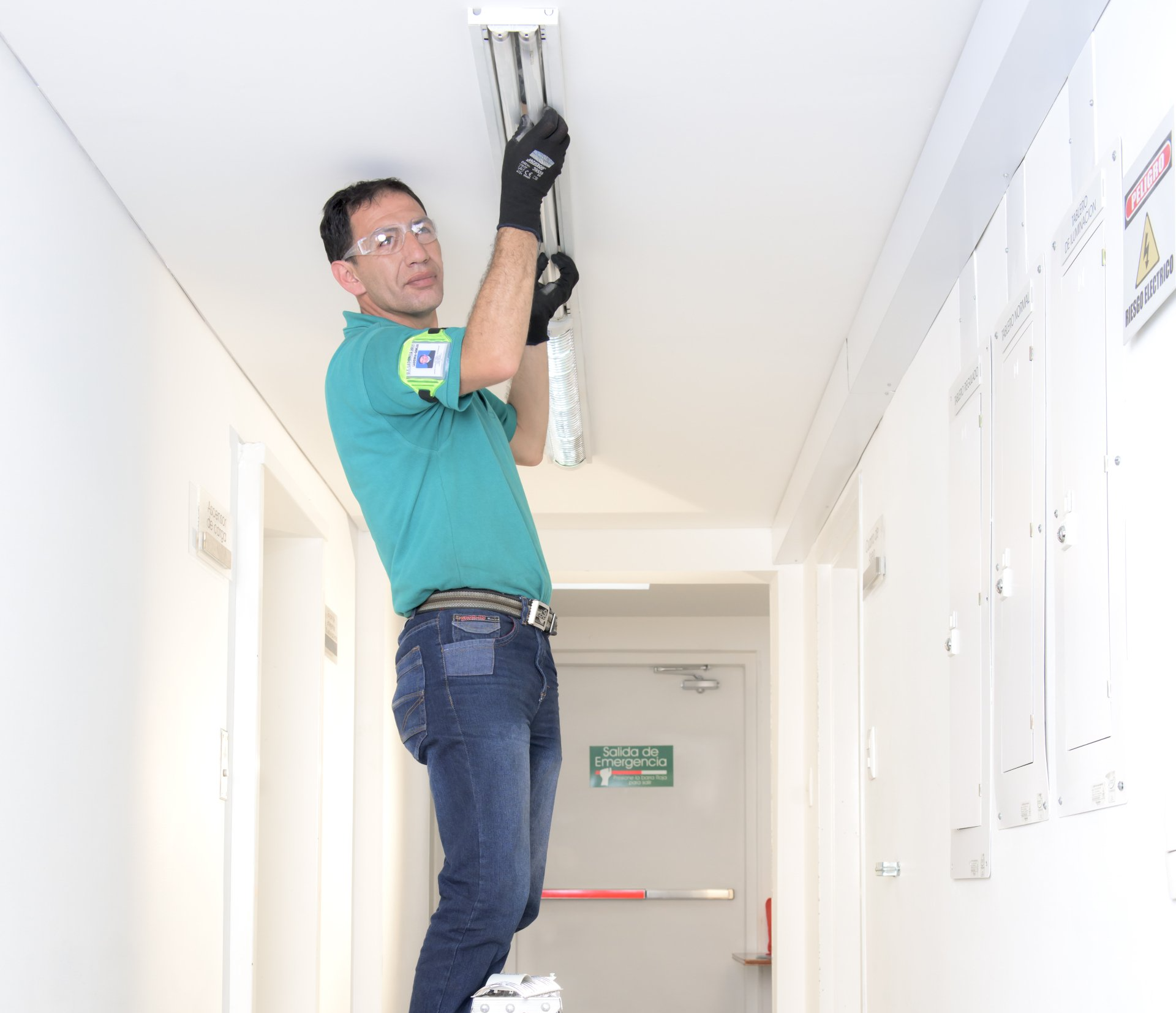 Un hombre está trabajando en una lámpara en un pasillo.