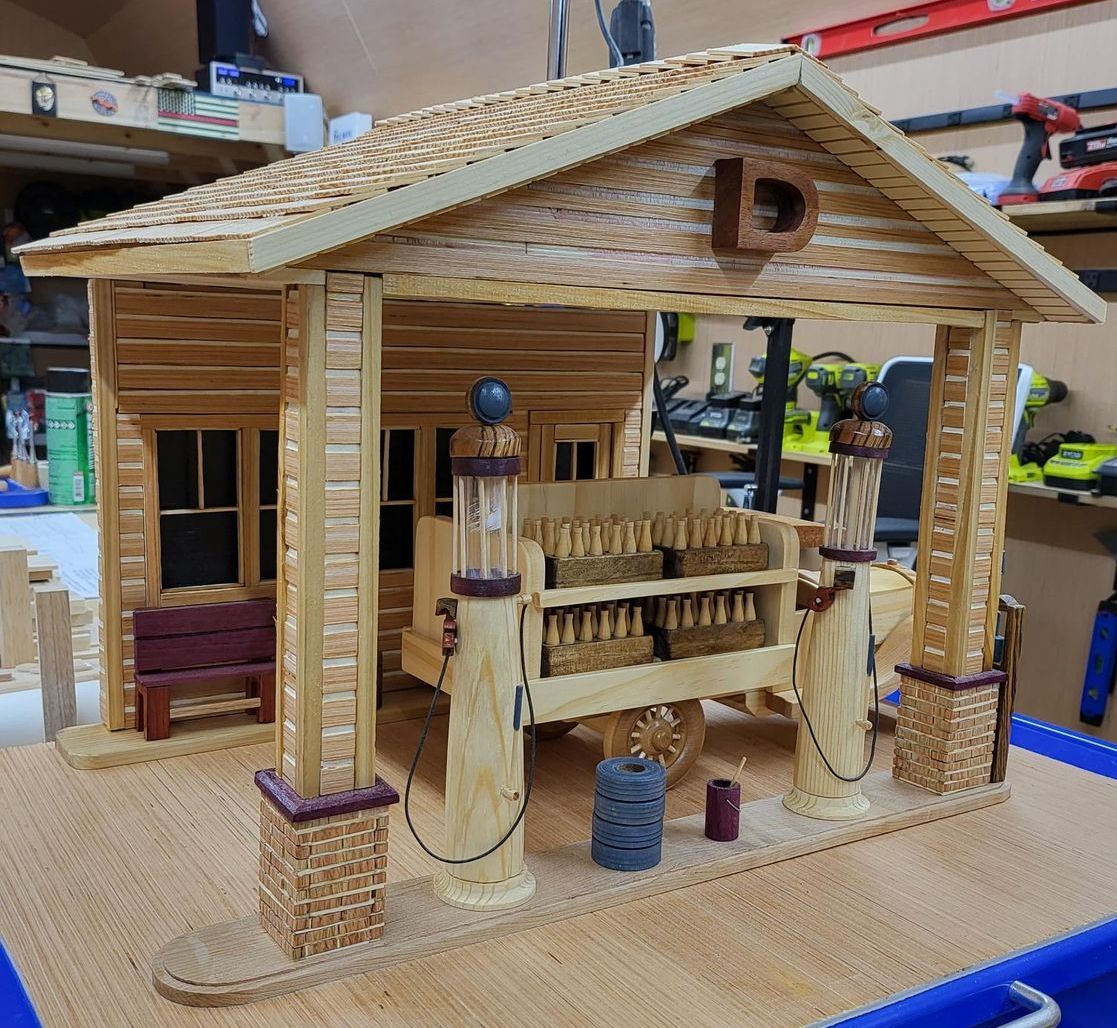 Wooden miniature gas station model with brown and purple details.