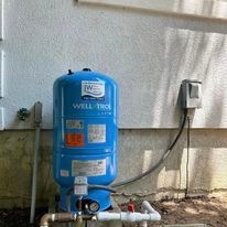 A blue well tank installation attached to the side of a house in Bayville, NJ. 