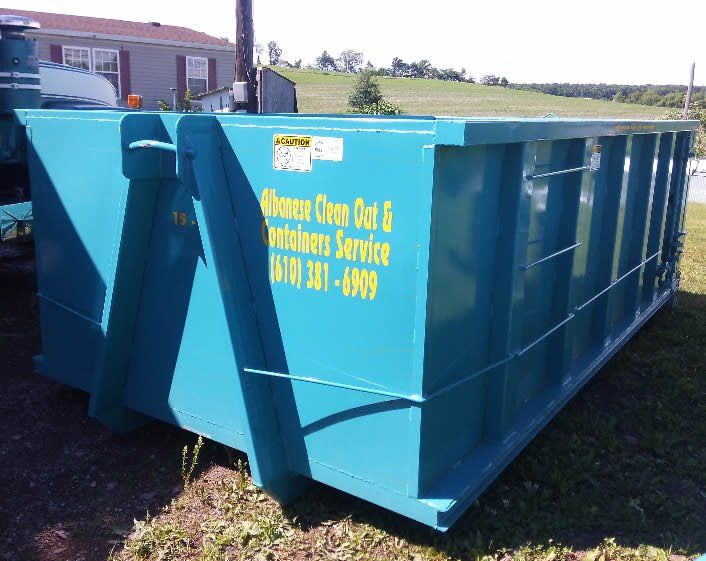 A blue dumpster that says dumpster over out & machinery service