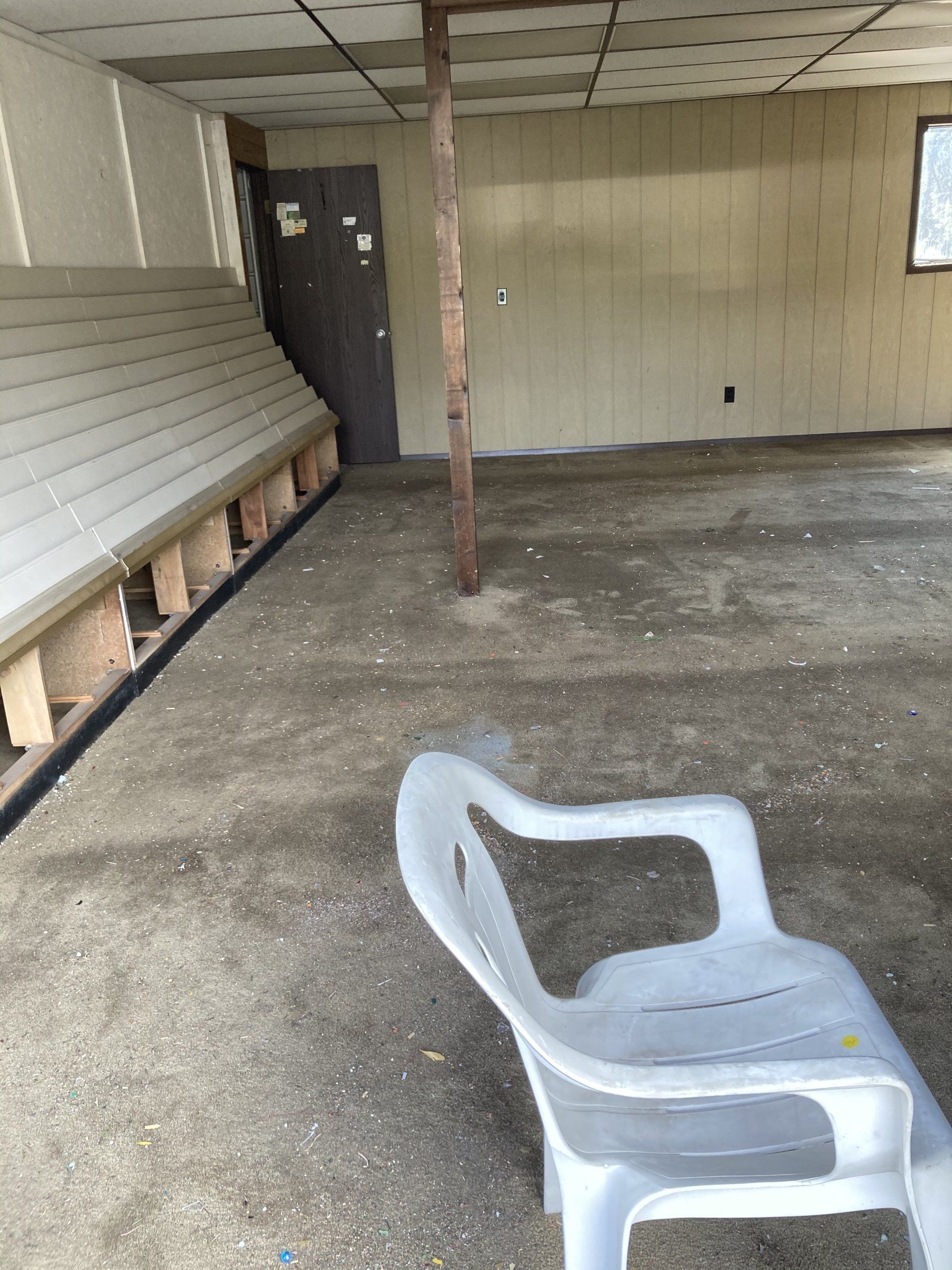 An empty room with a white chair in the middle