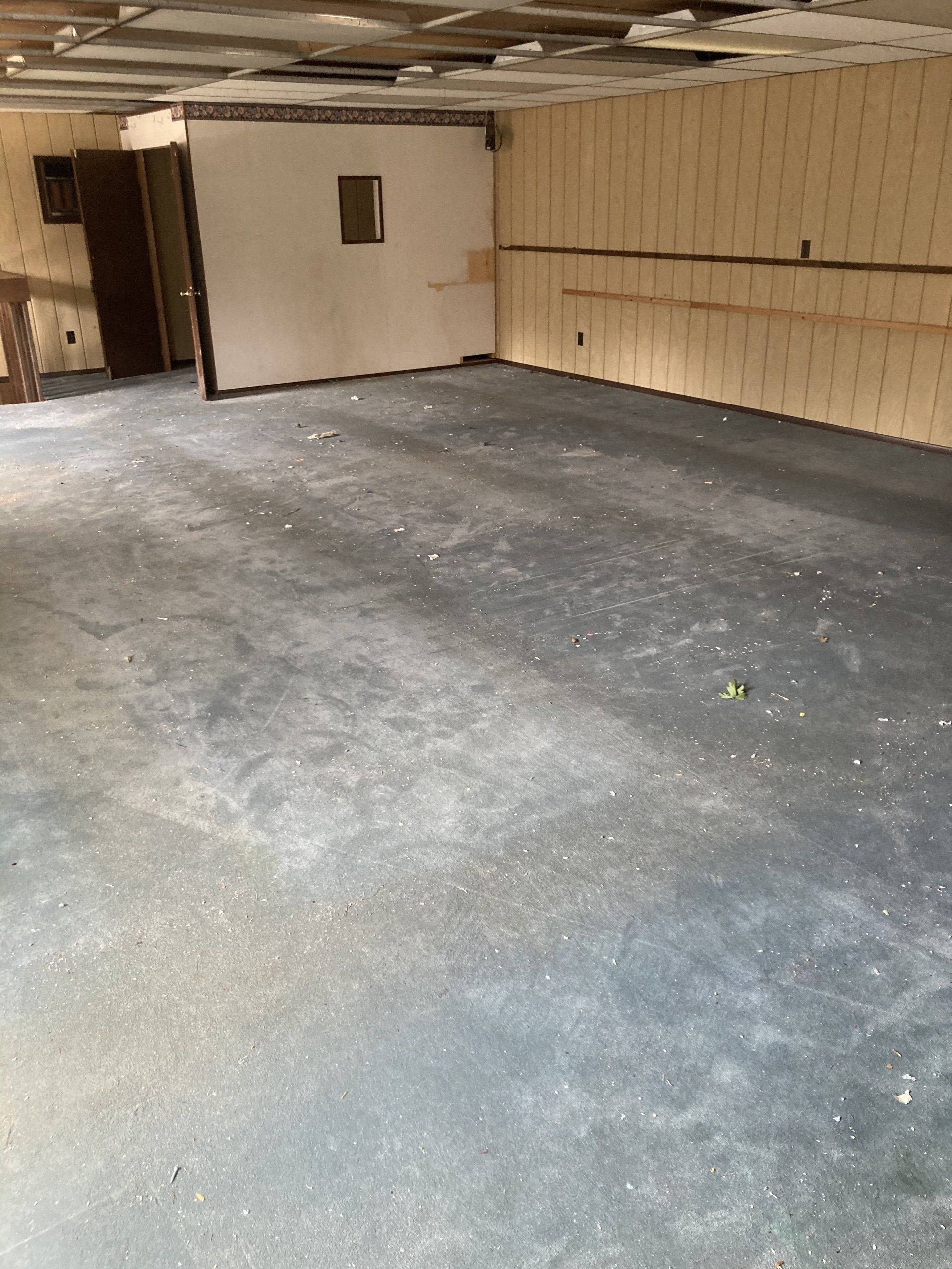 An empty room with a concrete floor and wooden walls