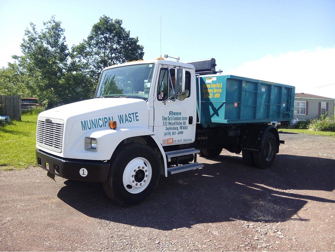 A dump truck with the word waste on the side