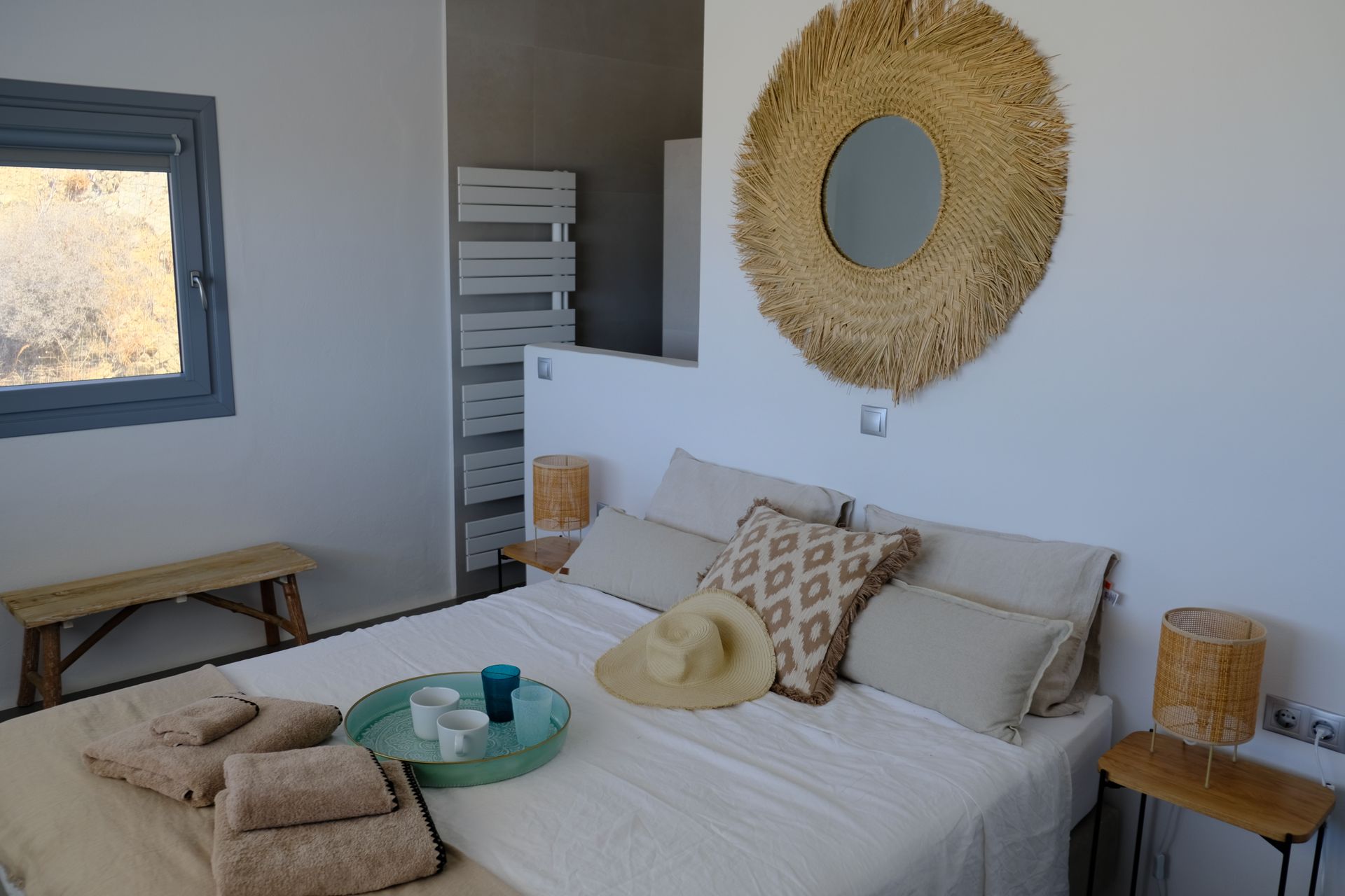 A bedroom with a large bed and a mirror on the wall.