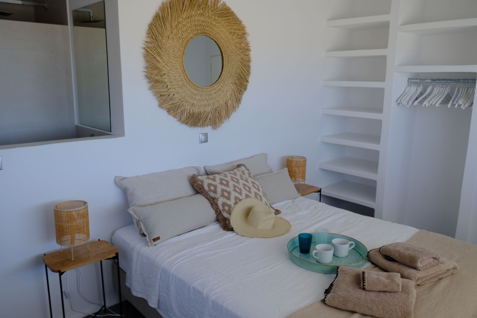 A bedroom with a bed and a mirror on the wall.