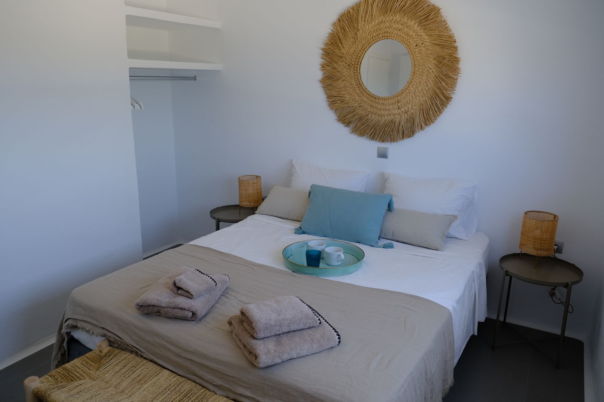 A bedroom with a bed and a mirror on the wall.