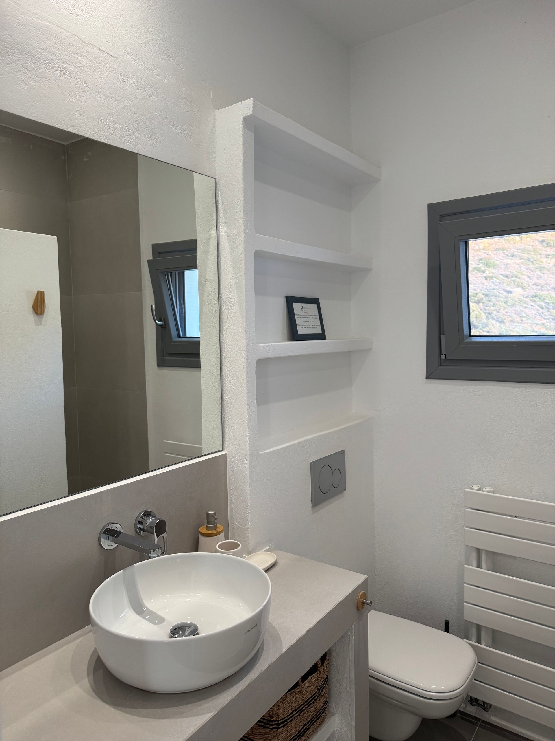A bathroom with a sink , toilet and mirror.