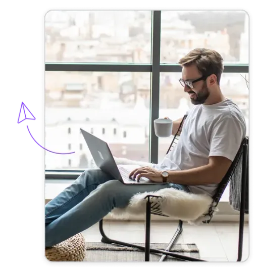 A man is sitting in a chair using a laptop computer.