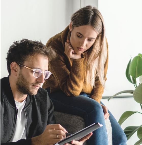 A man and a woman are looking at a tablet together