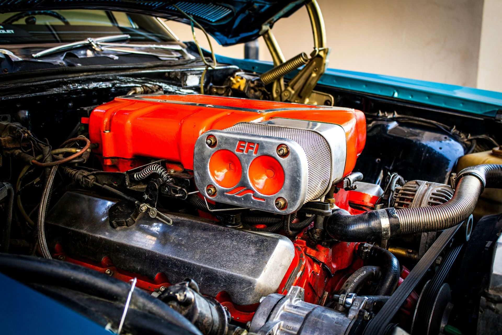 A close up of a car engine with the hood open.