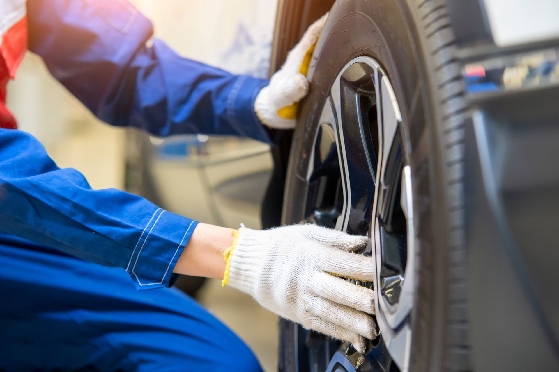 A mechanic is changing a tire on a car in a garage.