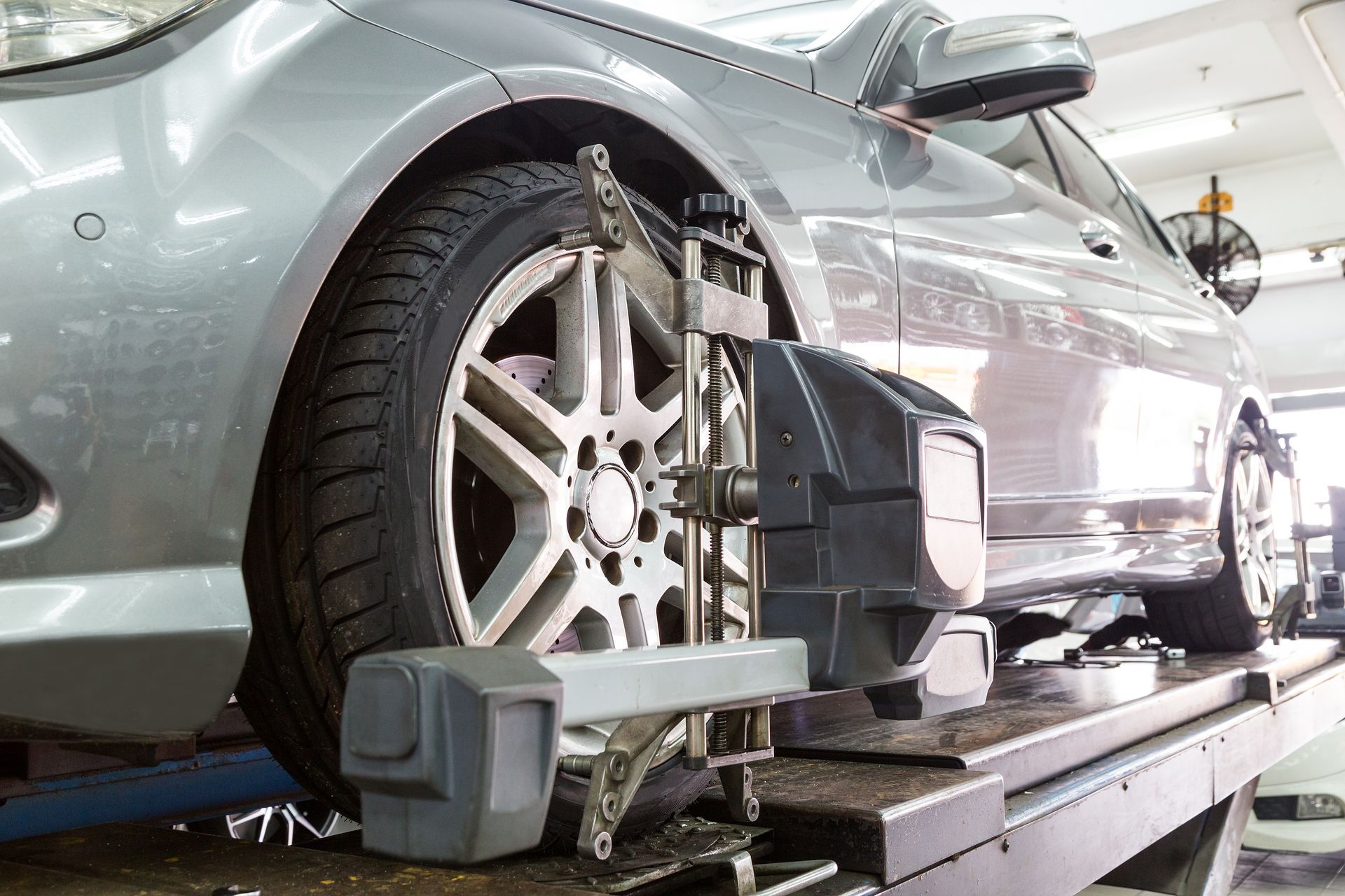 A car is being adjusted by a machine in a garage.