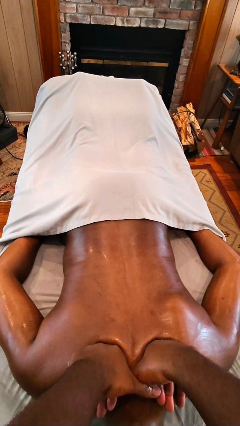 Hands massaging a bare back on a spa table