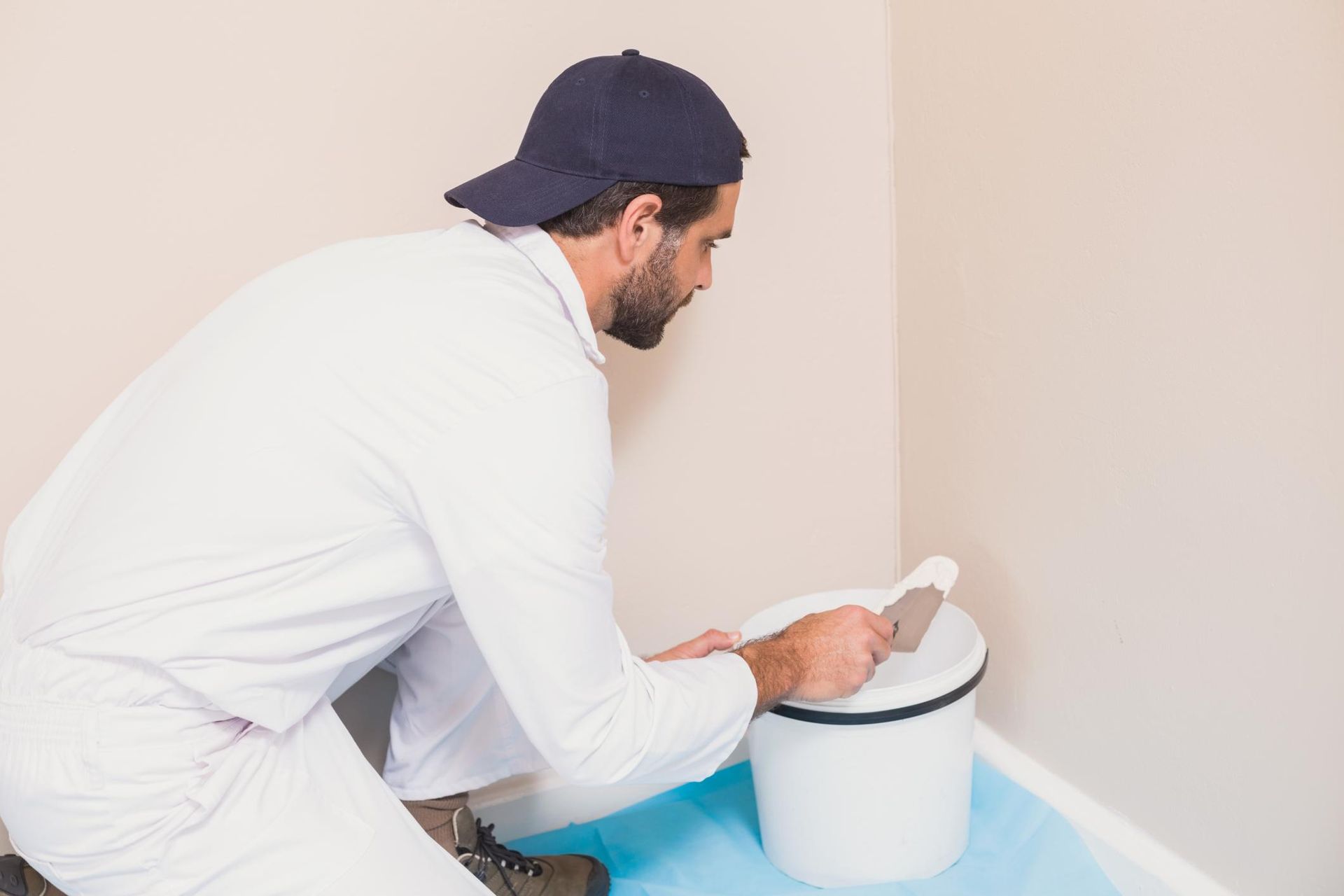 a man is using a spatula to paint a wall