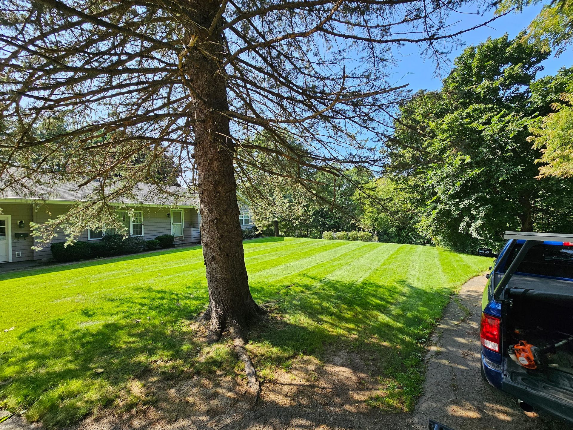 A truck is parked in front of a house with a lush green lawn.
