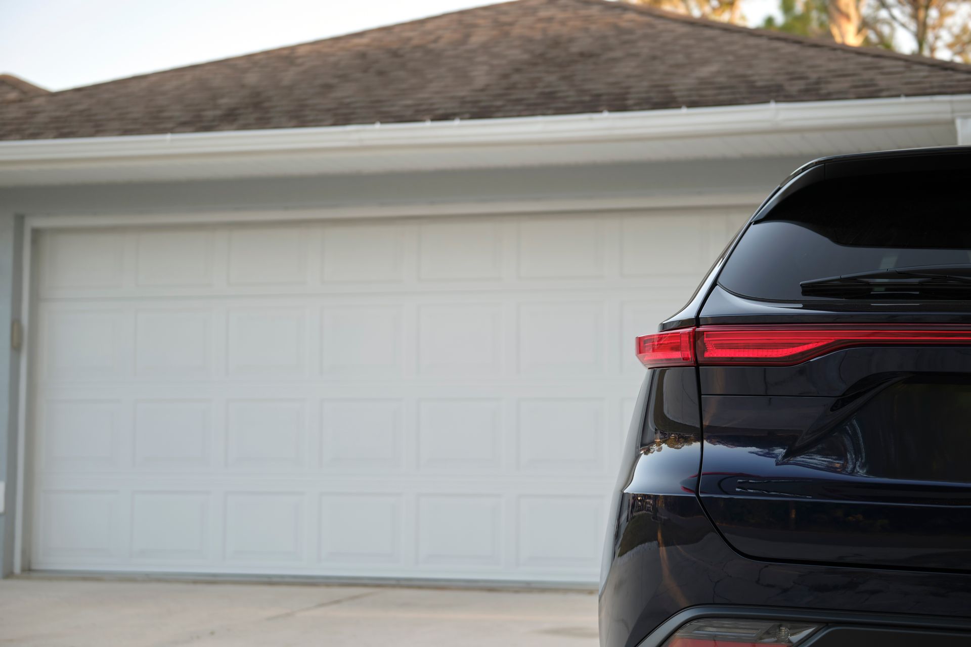 a black car is parked in front of a garage door .