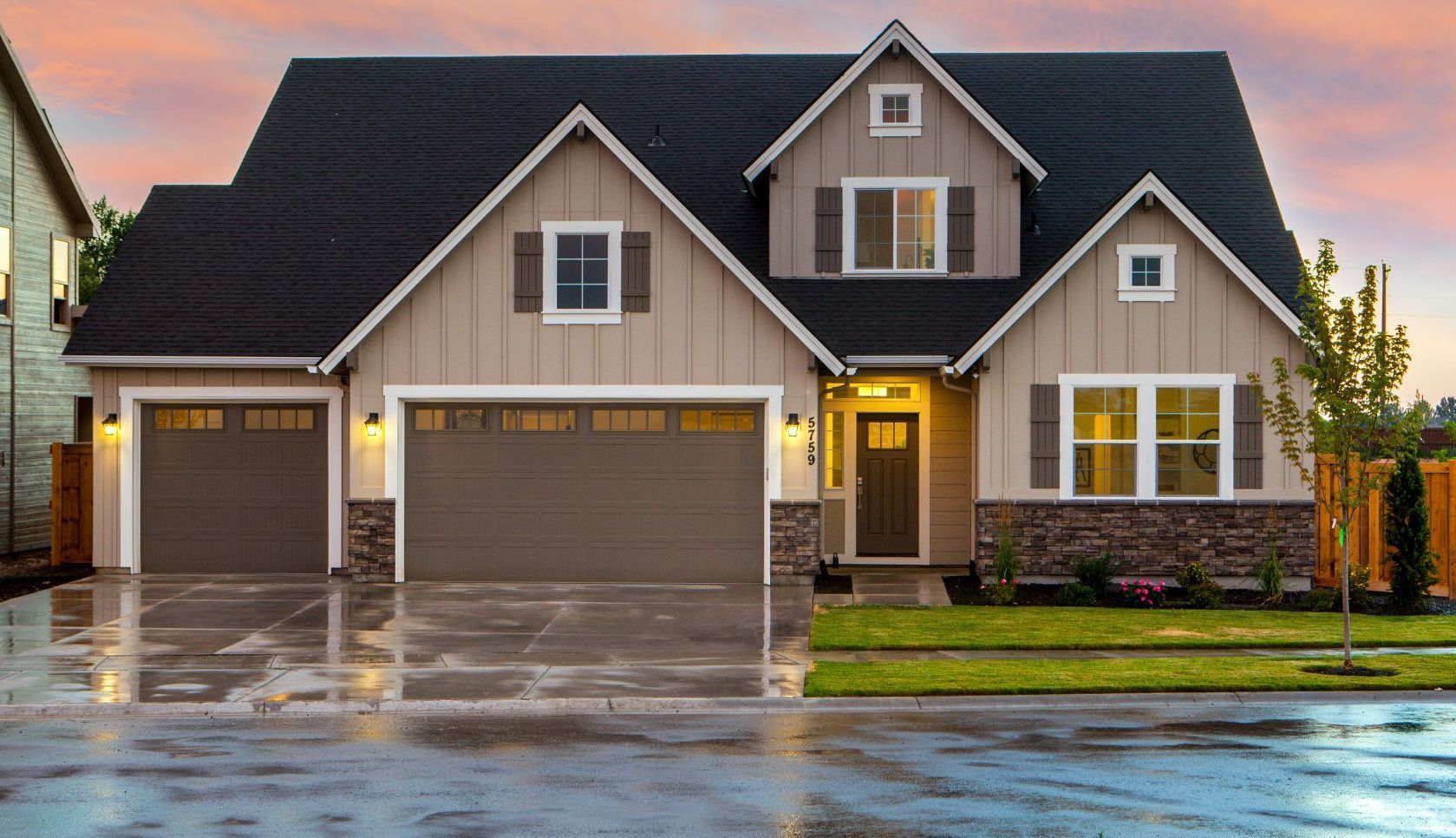 a large house with two garage doors and a driveway in front of it .