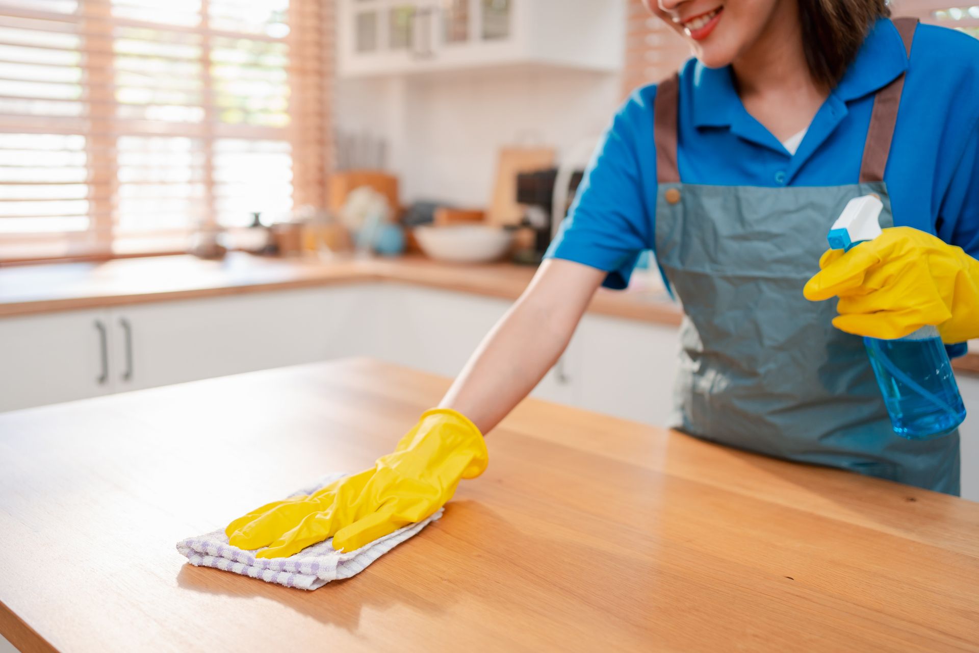 Person cleaning kitchen counter with cloth and spray bottle. Person cleaning kitchen counter with cloth and spray bottle.