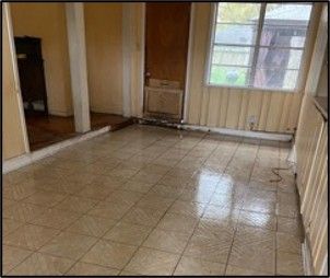 An empty room with a tiled floor and a window.