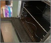 A picture of a dirty oven with the door open.