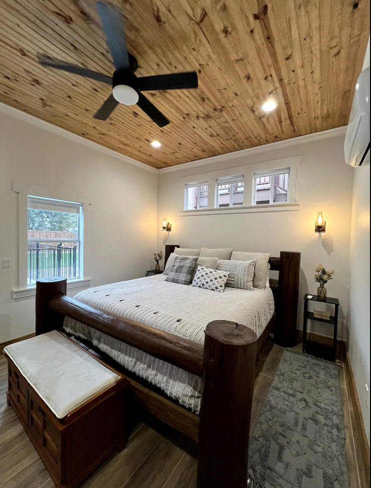 A bedroom with a king size bed and a ceiling fan.