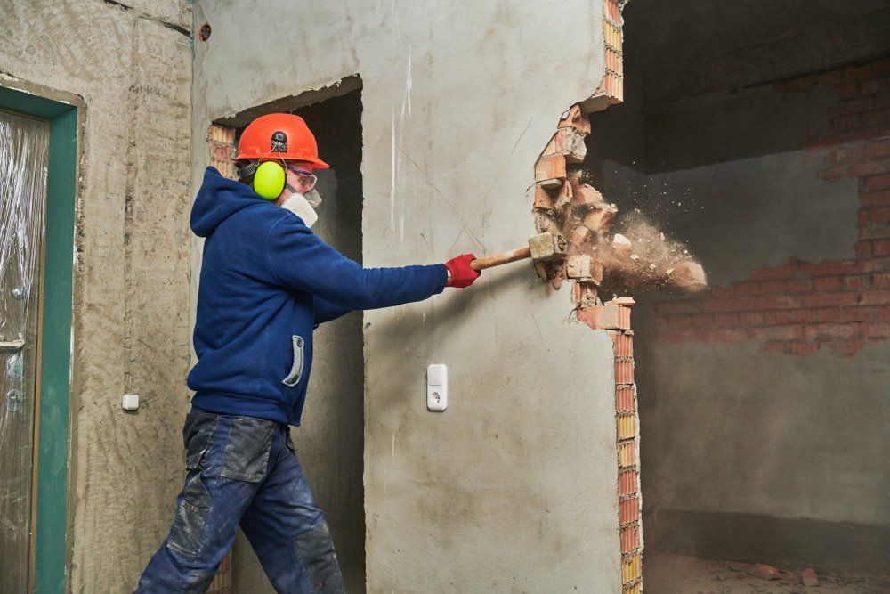 Worker With Sledgehammer Destroying Wall — Builders in Sydney, NSW
