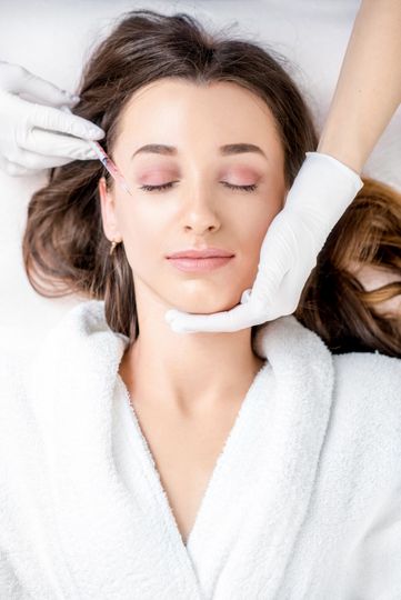 A woman is getting a botox injection in her face.