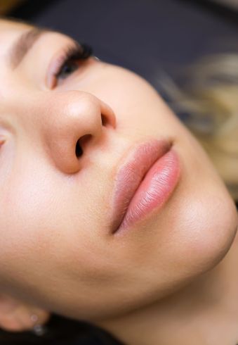 A close up of a woman 's face with her eyes closed.