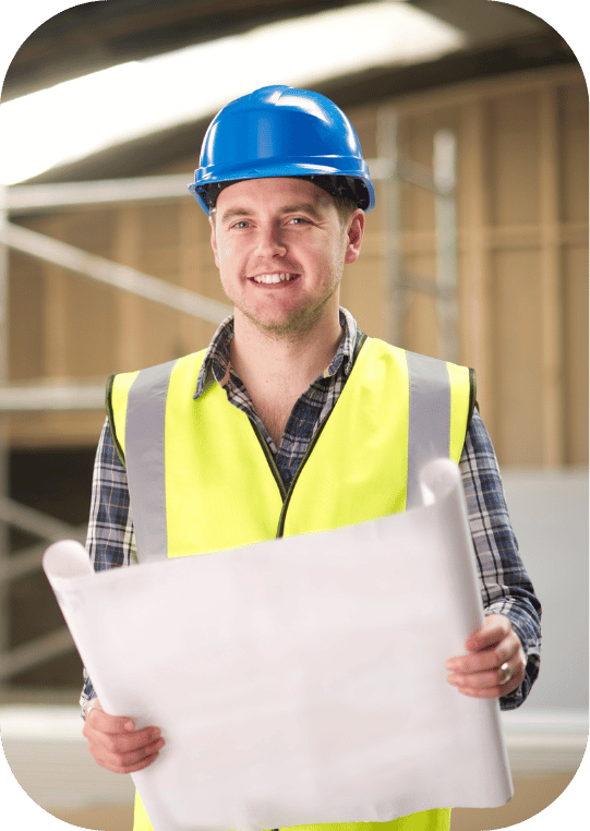 A man wearing a hard hat and safety vest is holding a blueprint.