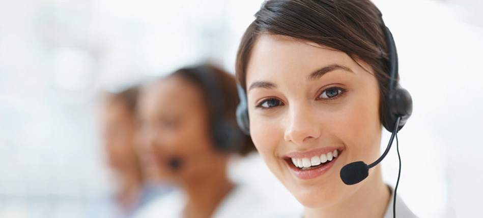 A woman wearing a headset is smiling in a call center.