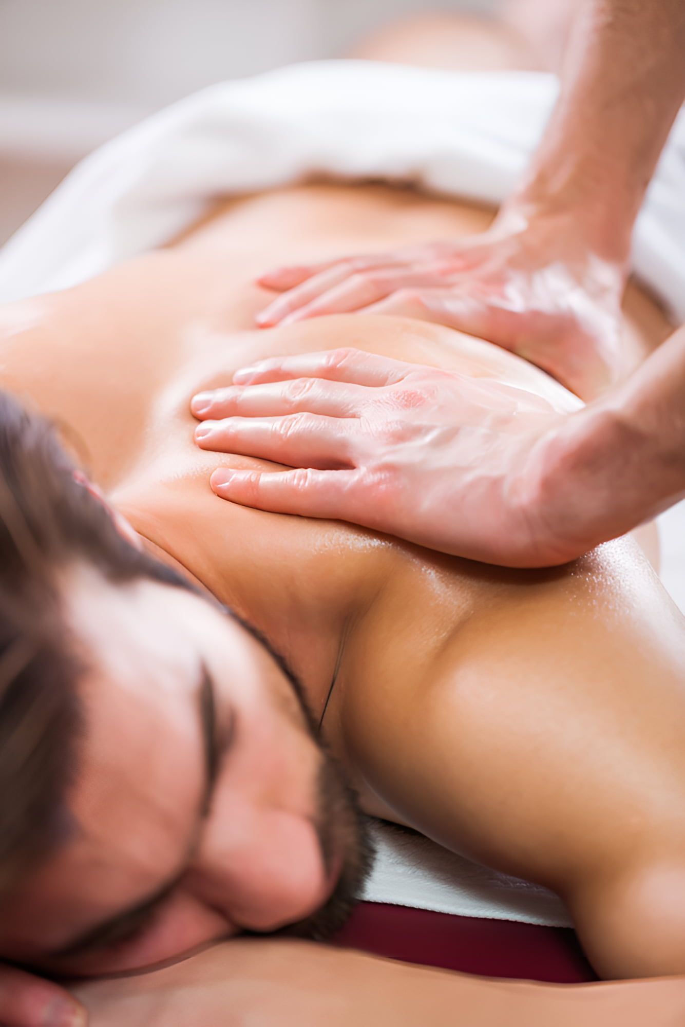 A Man Is Getting A Massage At A Spa — Back In Motion Chiropractic & Healthcare In Mission Beach, QLD