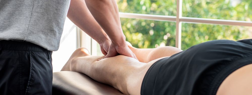 A Person Is Getting A Massage On Their Leg — Back In Motion Chiropractic & Healthcare In Mission Beach, QLD