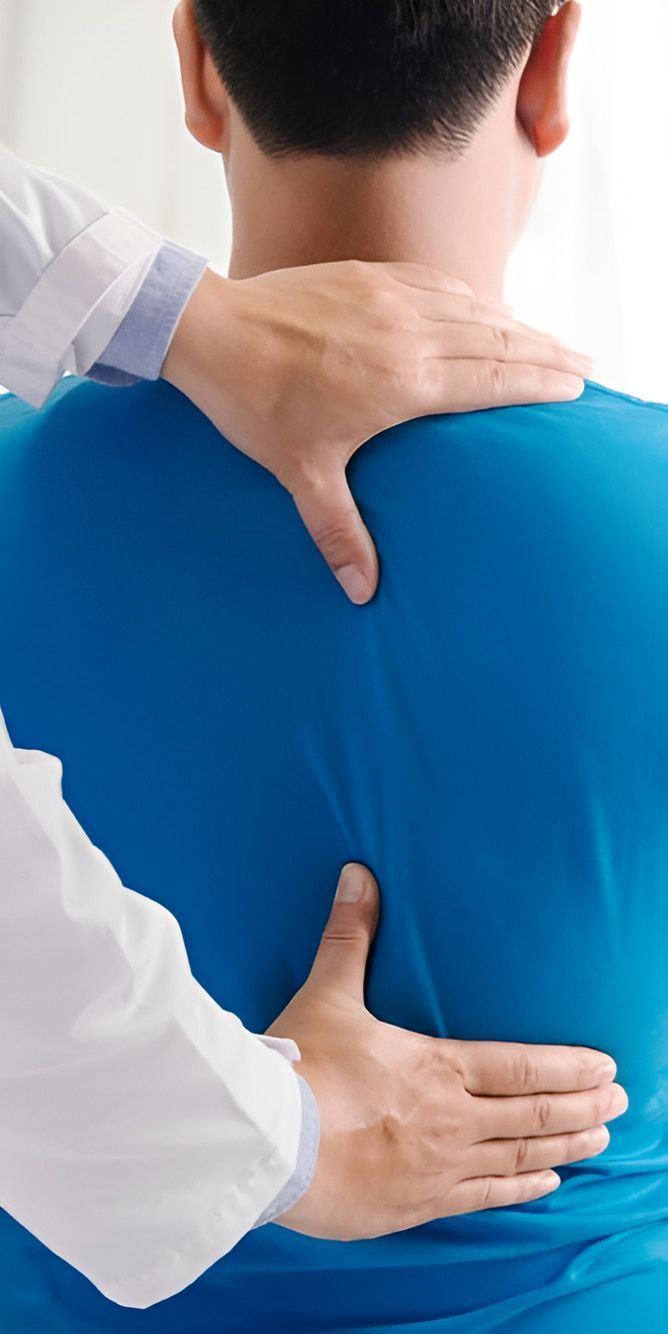A Doctor Is Examining A Patient 's Back And Neck — Back In Motion Chiropractic & Healthcare In Innisfail, QLD