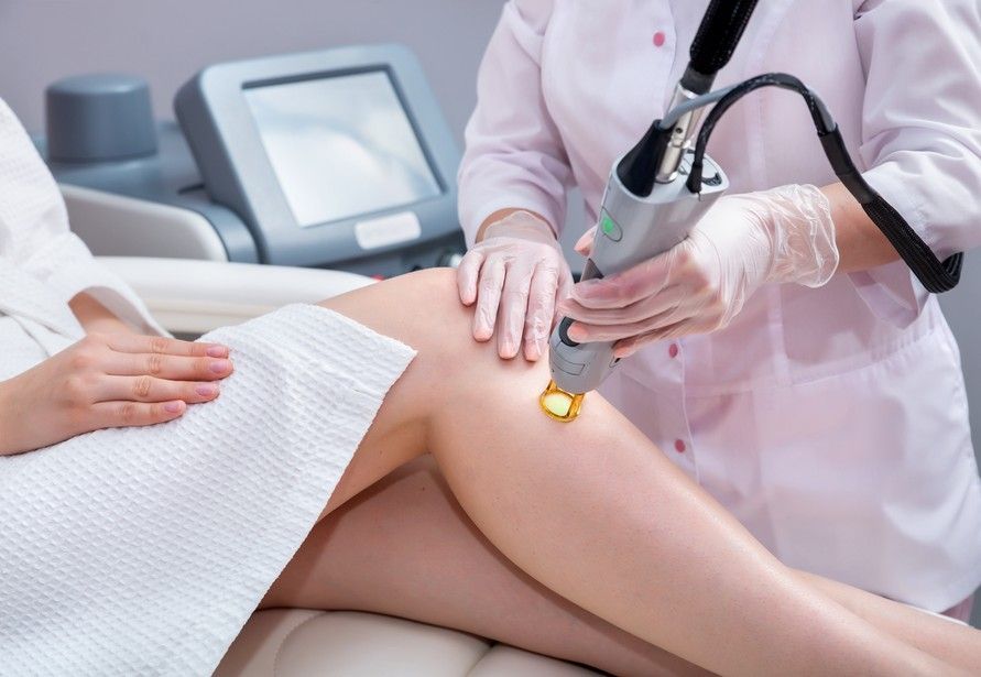 A Woman is Getting a Laser Hair Removal Treatment on Her Legs — Back In Motion Chiropractic & Healthcare In Innisfail, QLD