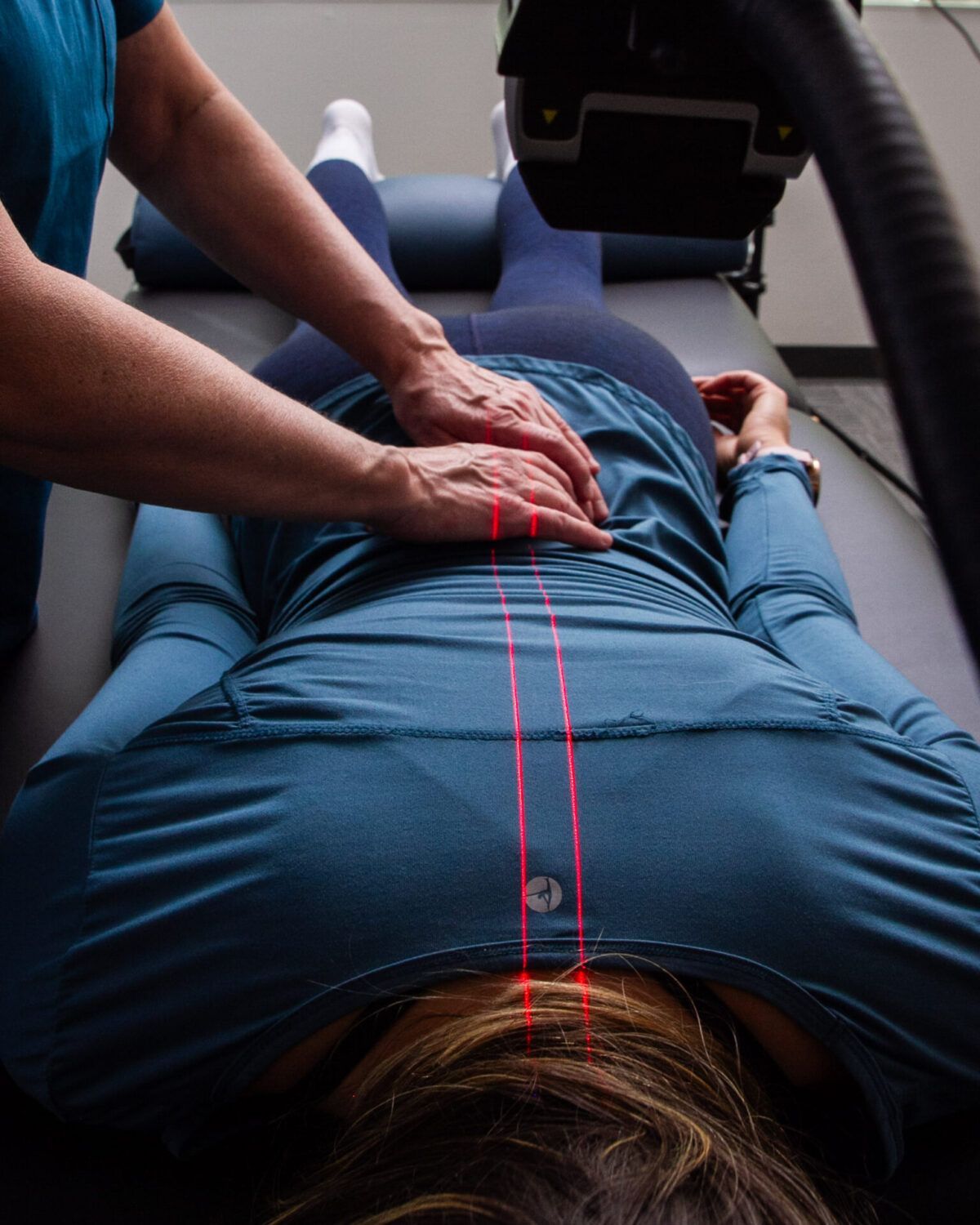 A Woman is Getting a Laser Hair Removal Treatment on Her Legs — Back In Motion Chiropractic & Healthcare In Innisfail, QLD