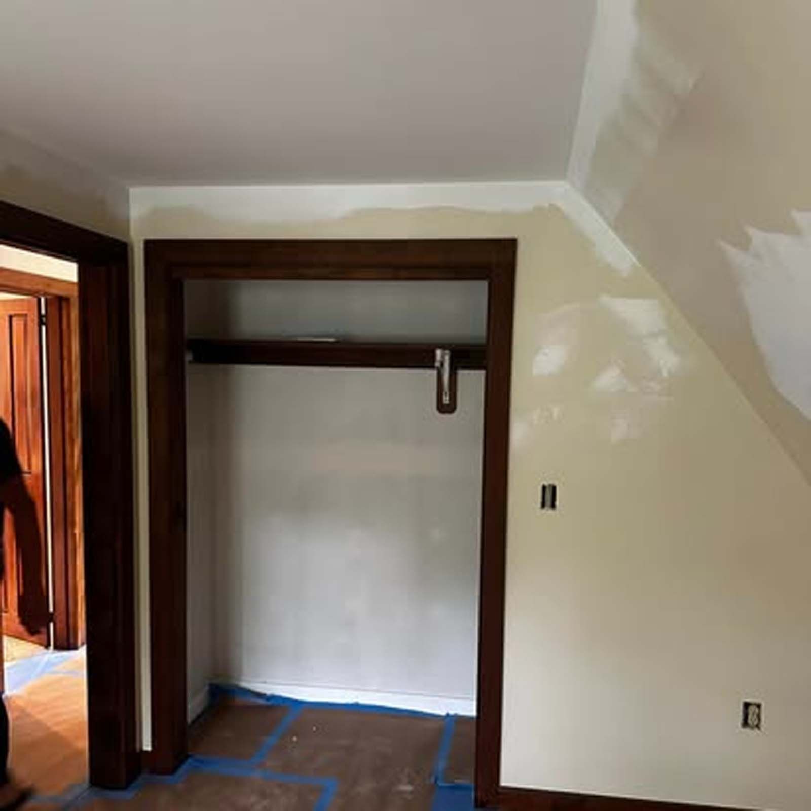 A man is standing in a room with a closet in it.