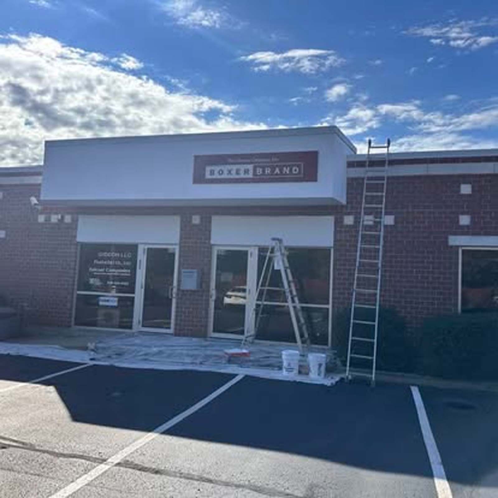 A ladder is sitting in front of a building that is being painted.
