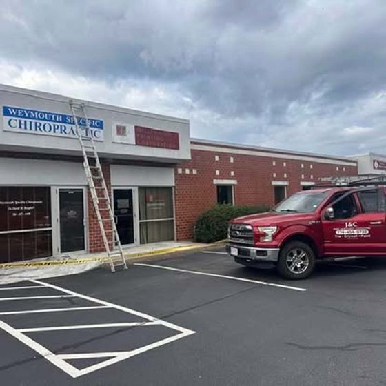 A red truck is parked in front of a brick building.