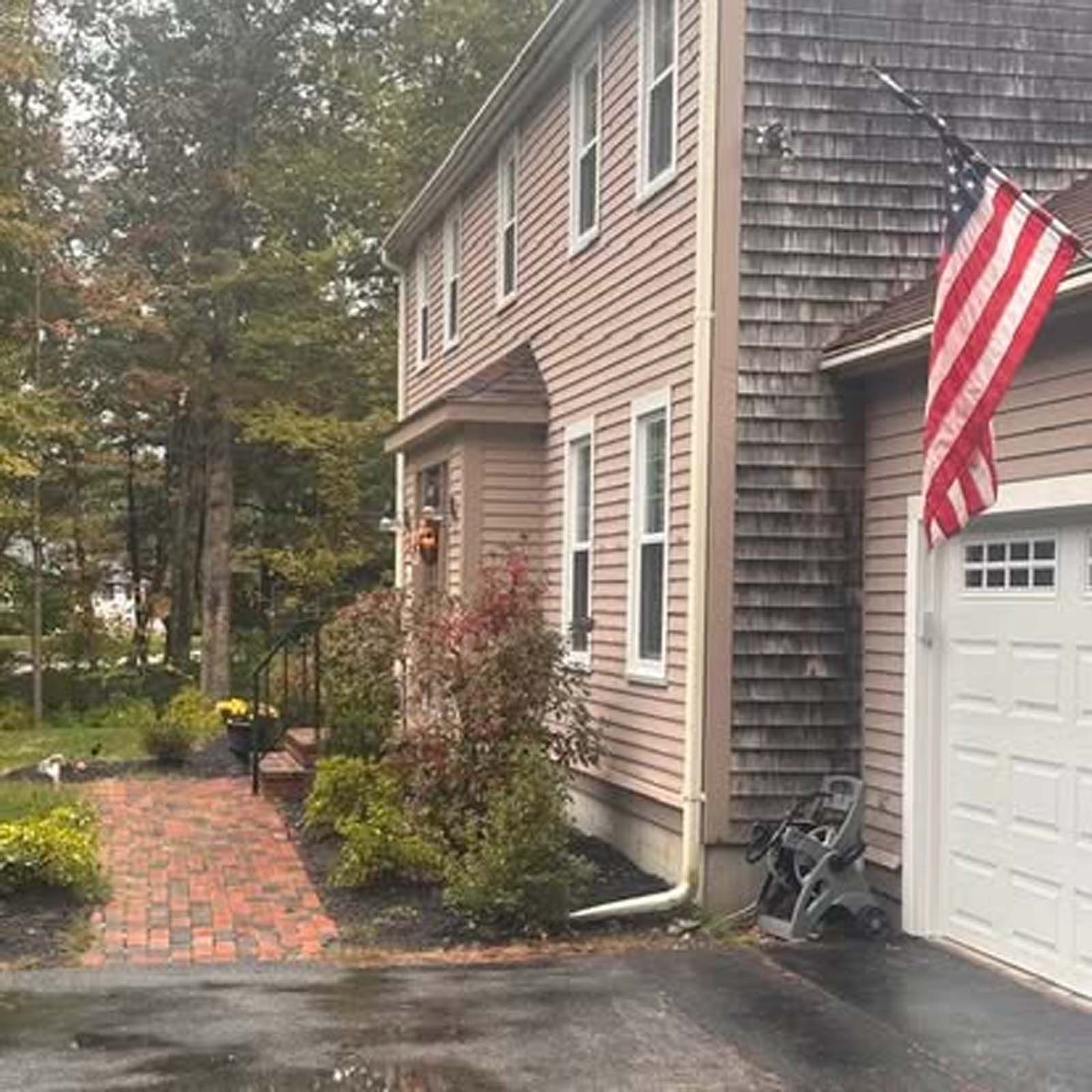 A house with an american flag hanging from the garage door